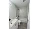 Bathroom showcasing a white vanity, toilet, and tub/shower with black fixtures and marble look tile at 17459 Sw 17Th Cir, Ocala, FL 34473