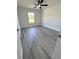 Bedroom with gray wood flooring, white walls, ceiling fan and a window at 17459 Sw 17Th Cir, Ocala, FL 34473