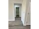 Hallway view leading to bathroom featuring grey wood flooring and white doors and trim at 17459 Sw 17Th Cir, Ocala, FL 34473