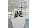 Spacious kitchen featuring stainless steel appliances, white cabinets, modern lighting, and a large island with quartz countertops at 17459 Sw 17Th Cir, Ocala, FL 34473