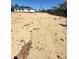 A mostly clear lot with sandy soil is ready for a new build in this natural setting near trees and a bright white home at 17459 Sw 17Th Cir, Ocala, FL 34473