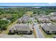 Aerial view of townhomes with lush landscaping and a beautiful lake view at 17519 Promenade Dr, Clermont, FL 34711
