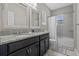 Well-lit bathroom with dual sinks, a shower-tub, and granite countertops at 17519 Promenade Dr, Clermont, FL 34711