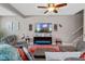 Cozy living room with a ceiling fan, modern electric fireplace, comfortable seating and stairs to the second floor at 17519 Promenade Dr, Clermont, FL 34711