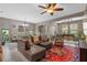 Expansive living room is open to the dining room, featuring a large sectional couch and plenty of natural light at 17519 Promenade Dr, Clermont, FL 34711