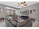 Spacious living room featuring comfortable seating, a ceiling fan, and a modern electric fireplace with decor at 17519 Promenade Dr, Clermont, FL 34711