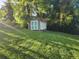 Backyard shed in grassy yard surrounded by lush trees and greenery at 1765 Hilltop Dr, Mount Dora, FL 32757