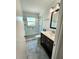 Bright bathroom featuring a tiled glass shower and dark wood vanity with elegant faucet and mirror at 1765 Hilltop Dr, Mount Dora, FL 32757