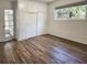 Bright bedroom with hardwood floors, built-in closet, and door to enclosed porch at 1765 Hilltop Dr, Mount Dora, FL 32757
