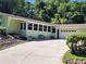Charming home featuring an attached garage, large driveway, and ample greenery surrounding the property at 1765 Hilltop Dr, Mount Dora, FL 32757