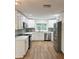 Modern kitchen featuring white cabinetry, stainless steel appliances, quartz countertops and wood look flooring at 1765 Hilltop Dr, Mount Dora, FL 32757
