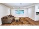 Spacious living room with a couch, area rug, and wood-look flooring at 1765 Hilltop Dr, Mount Dora, FL 32757