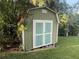Green and white shed surrounded by lush greenery on a sunny day at 1765 Hilltop Dr, Mount Dora, FL 32757
