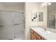 Bathroom featuring a step-in shower with glass doors, laminate cabinets, and a large vanity mirror at 1833 Endsley Ct, The Villages, FL 32162