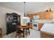 Kitchen area with wood cabinets, white appliances, black hutch, and tile floor at 1833 Endsley Ct, The Villages, FL 32162