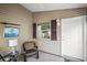 Cozy enclosed sun room featuring a comfortable chair, natural light, and access door at 1833 Endsley Ct, The Villages, FL 32162