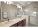Bathroom with a double sink vanity, framed mirrors, and glass-enclosed walk-in shower at 2064 Edenton Ter, The Villages, FL 32162