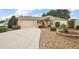 Charming single-story home featuring a gravel and garden bed front yard and two car garage at 2064 Edenton Ter, The Villages, FL 32162
