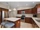 Stylish kitchen with stainless steel appliances, a center island, and dark wood cabinets at 2064 Edenton Ter, The Villages, FL 32162