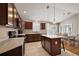 Bright kitchen features dark wood cabinetry, light countertops, and stainless steel appliances at 2064 Edenton Ter, The Villages, FL 32162