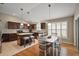 Spacious kitchen and dining area with dark cabinets, stainless steel appliances, and wood floors at 2064 Edenton Ter, The Villages, FL 32162