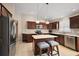Modern kitchen featuring stainless steel appliances, an island with seating, and tile flooring at 2064 Edenton Ter, The Villages, FL 32162