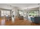 Cozy living room featuring wood floors, natural light, comfortable seating, and a dining area at 2064 Edenton Ter, The Villages, FL 32162