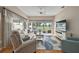 Bright living room featuring large windows with golf course views, comfortable seating, and a ceiling fan at 2064 Edenton Ter, The Villages, FL 32162