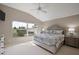 Primary bedroom with large window and views of the backyard, and decorative lamps at 2064 Edenton Ter, The Villages, FL 32162