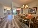 Elegant dining room with a chandelier, view to the kitchen, and modern flooring at 2071 Westchester Way, The Villages, FL 32162