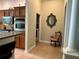 Hallway leading to kitchen area, featuring tile flooring and decorative accents at 2071 Westchester Way, The Villages, FL 32162
