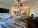 Comfortable living room featuring modern sofas, a ceiling fan, and wood-look flooring at 2071 Westchester Way, The Villages, FL 32162