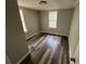 A simple bedroom with wood-look flooring and natural light from two windows at 2107 Hollywood Ave, Eustis, FL 32726