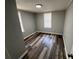 A simple bedroom with wood-look flooring and natural light from two windows at 2107 Hollywood Ave, Eustis, FL 32726