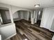 A spacious living room featuring wood-look flooring and lots of natural light from windows at 2107 Hollywood Ave, Eustis, FL 32726