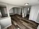 A spacious living room featuring wood-look flooring and lots of natural light from windows at 2107 Hollywood Ave, Eustis, FL 32726