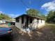 Property side view showing covered front porch and neutral brick exterior at 2107 Hollywood Ave, Eustis, FL 32726