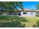 The exterior of the home features a well-maintained backyard with lush grass and a screened-in patio at 223 Crepe Myrtle Dr, Groveland, FL 34736