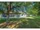 The backyard features lush green grass, mature trees and a screened-in patio, providing ample space at 223 Crepe Myrtle Dr, Groveland, FL 34736