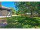 Spacious backyard featuring lush lawn, mature trees, and screened-in lanai, perfect for outdoor living at 223 Crepe Myrtle Dr, Groveland, FL 34736