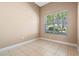 A neutral bedroom with tile flooring, and a large window at 223 Crepe Myrtle Dr, Groveland, FL 34736