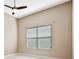Neutral bedroom with a ceiling fan and a window with white blinds at 223 Crepe Myrtle Dr, Groveland, FL 34736