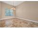 Neutral dining room with tile floors, chandelier, and view of window with blinds at 223 Crepe Myrtle Dr, Groveland, FL 34736