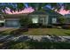 Charming single-Gathering home featuring lush landscaping and a covered front porch entrance at 223 Crepe Myrtle Dr, Groveland, FL 34736