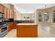 Open concept kitchen with island, stainless steel appliances and tile flooring at 223 Crepe Myrtle Dr, Groveland, FL 34736
