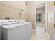 A bright laundry room is equipped with a modern washer and dryer and wire shelving at 223 Crepe Myrtle Dr, Groveland, FL 34736