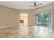 Spacious living area with tile flooring, sliding glass doors, and archway to another room at 223 Crepe Myrtle Dr, Groveland, FL 34736