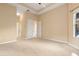 Main bedroom featuring carpet flooring, trey ceilings, and hallway access to an ensuite bath at 223 Crepe Myrtle Dr, Groveland, FL 34736