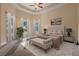 Bright main bedroom showcasing high ceilings, multiple windows, neutral decor, and an elegant upholstered bed frame at 223 Crepe Myrtle Dr, Groveland, FL 34736