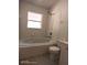 All-white bathroom featuring a bathtub, shower, and toilet with white tile throughout at 223 Lady Diana Dr, Davenport, FL 33837